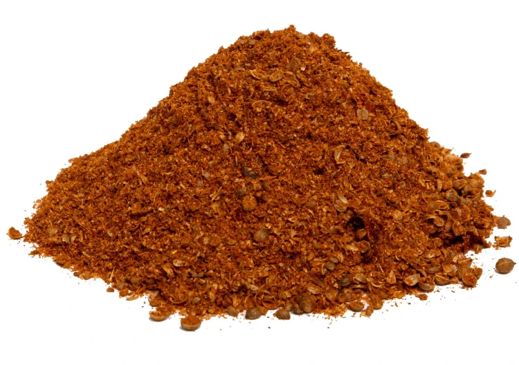 Harissa NMR to pikantna mieszanka przypraw z chilli, czosnkiem i kminem rzymskim. Idealna do mięs, jajek, zup, kuskusu i dipów. 100% naturalna, bez dodatków. Usypana na białym tle prezentując kolor i strukturę przyprawy.